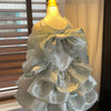 Silver ruffled pet dress with large satin bow on display mannequin, elegant pet clothing