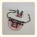 Pink and black lace pet costume set with frilly collar and lace bunny ear headband on a light surface