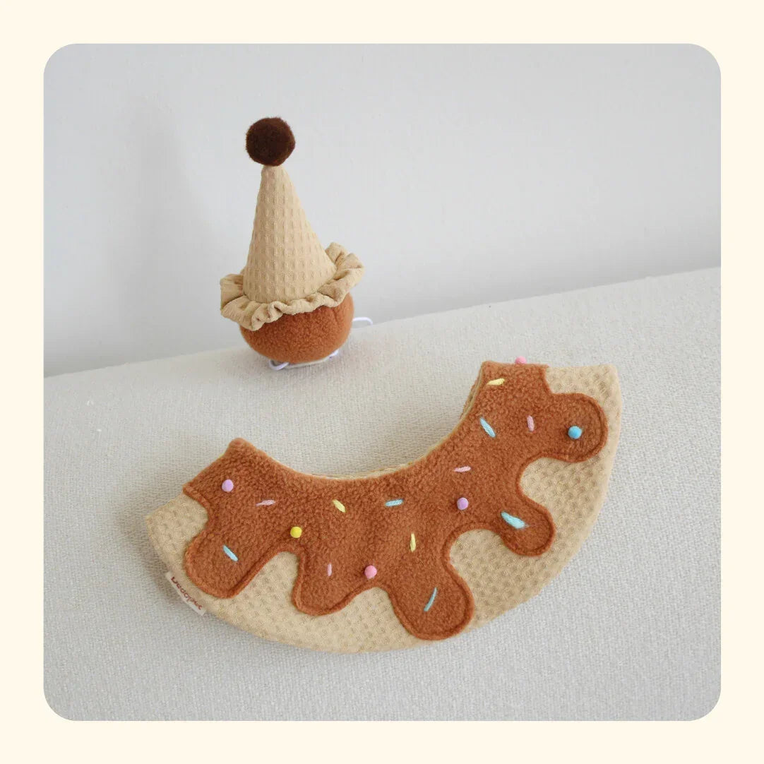 Ice cream cone pet hat and donut-shaped pet accessory with sprinkles on a light background