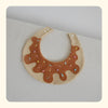 Cute pet bib shaped like a donut with colorful sprinkles and snap closures, on beige fabric.