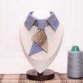 Designer pet tie collar with blue accents and plaid necktie, displayed on mannequin with spool